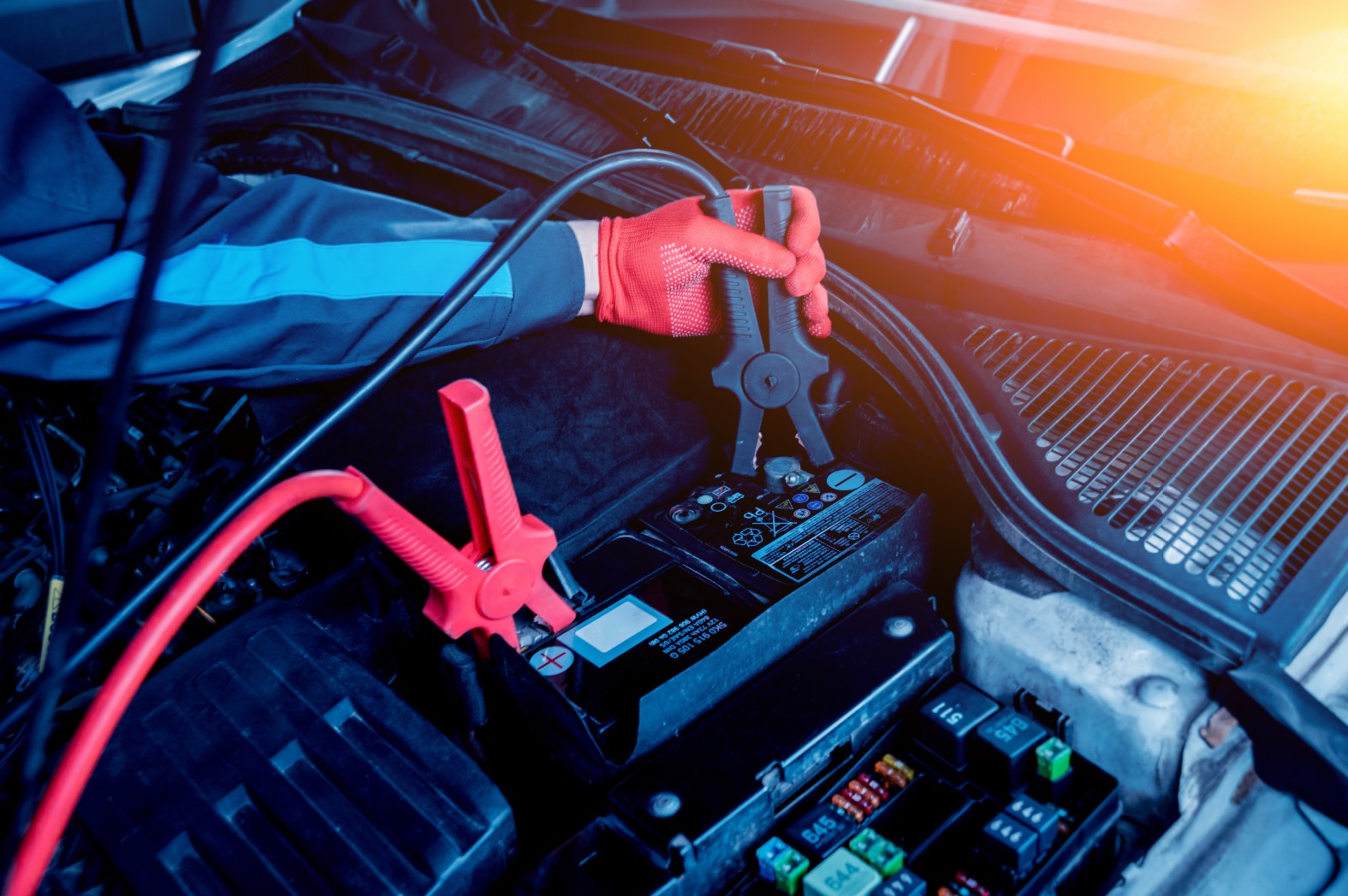 Technician jump starting a car battery in Kota